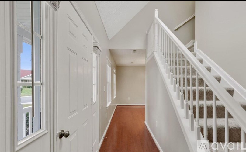 A hallway with a staircase and white doors.