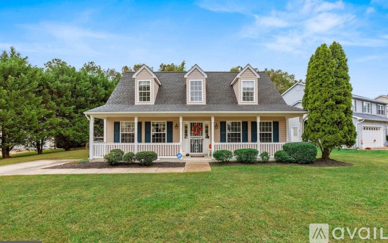 A house with a white porch and a red door is for sale.