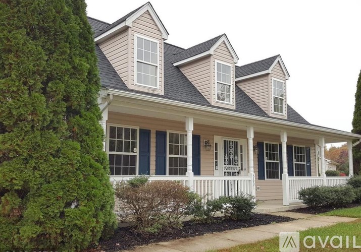 A house with a blue door and windows is for sale.