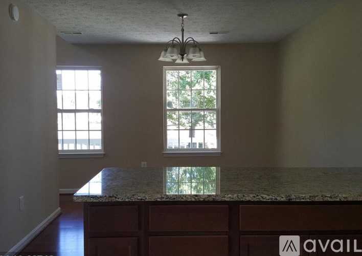 A kitchen with a granite countertop and a window.