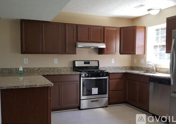 A kitchen with brown cabinets and a granite countertop.