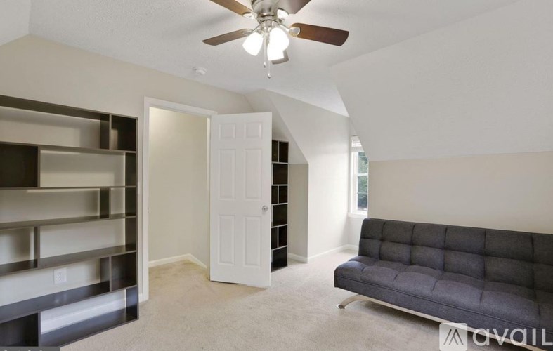 A living room with a grey sofa and a ceiling fan.