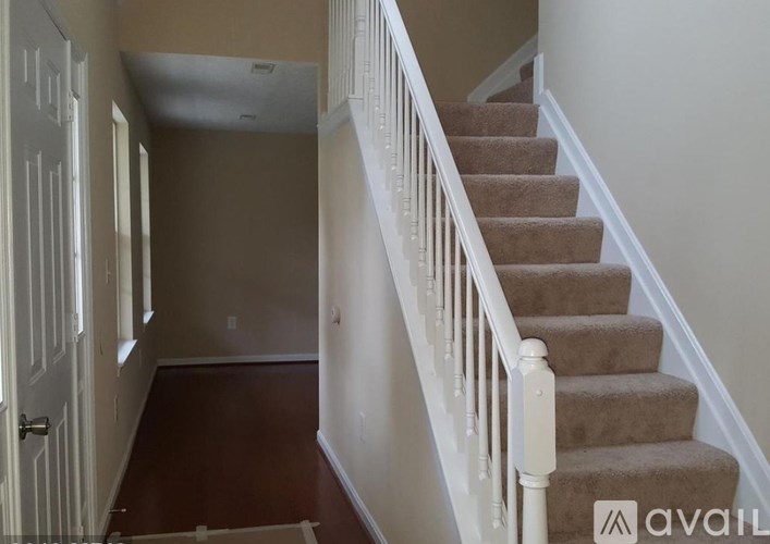 A staircase with a carpeted runner and white balusters.