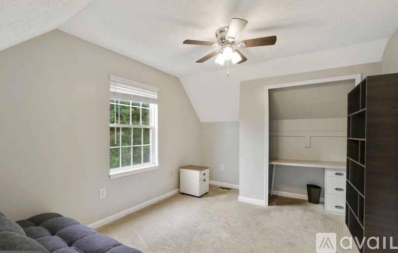 A room with a ceiling fan and a window.
