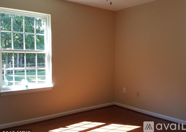 A room with a window and sunlight coming through.