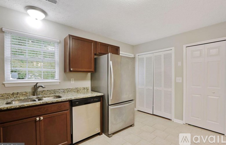 A kitchen with a refrigerator, sink, and cabinets.