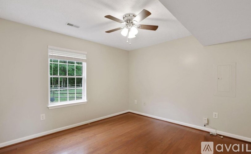 A room with a ceiling fan and a window.