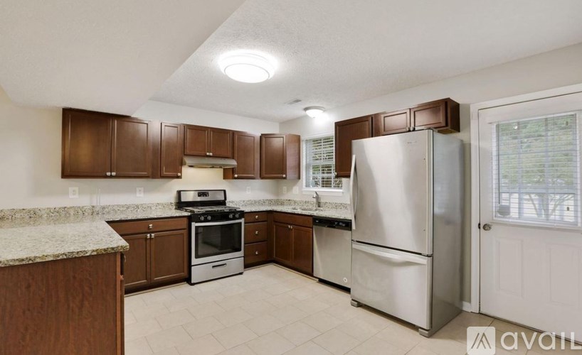 A kitchen with brown cabinets and a white refrigerator.