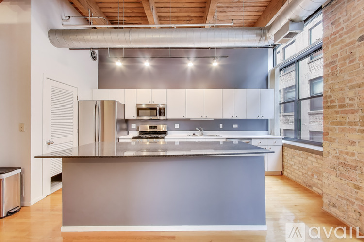 A modern kitchen with stainless steel appliances and a wooden ceiling.