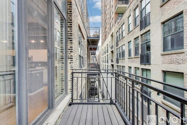 A balcony with a black railing and a glass wall on the left side.