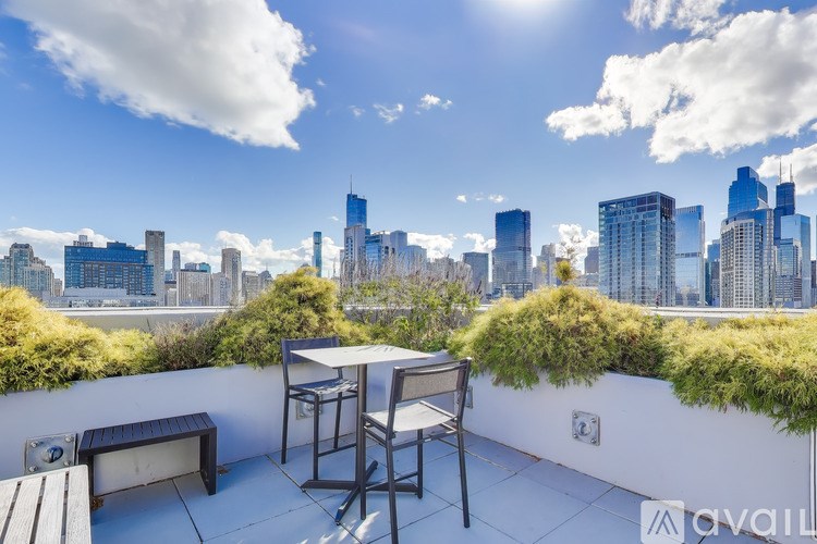 A patio with a table and chairs overlooking a city skyline.