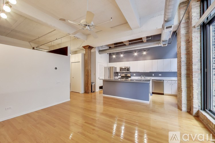 A spacious room with wooden floors and a ceiling fan.