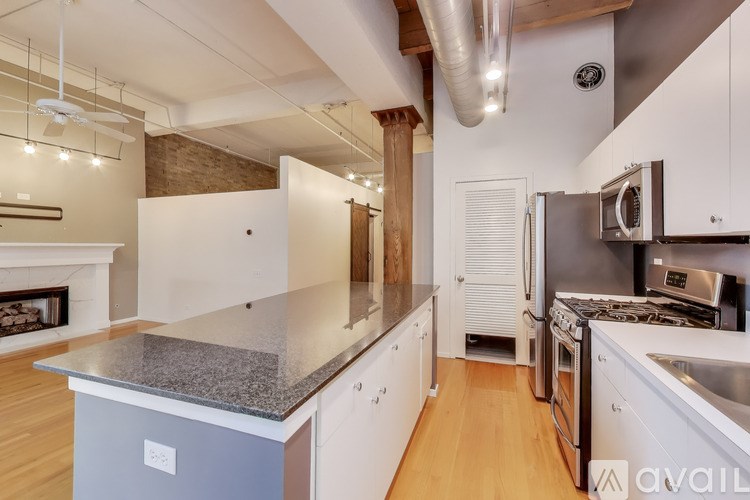 A kitchen with a granite countertop and stainless steel appliances.