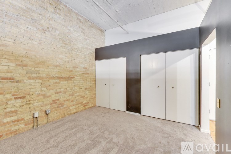 A room with a brick wall and a carpeted floor.