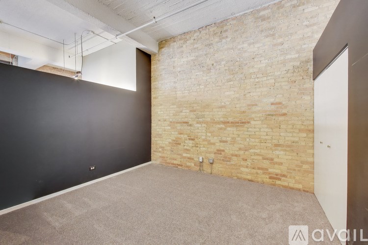A room with a brick wall and a carpeted floor.