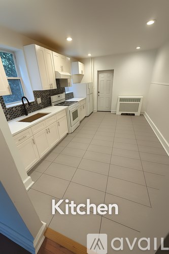 A kitchen with white cabinets and a tiled floor.