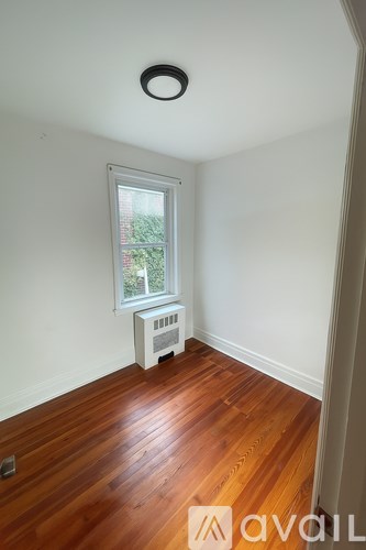 A room with wooden floors and a window.