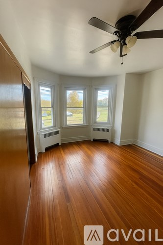 A room with wooden floors and a ceiling fan.