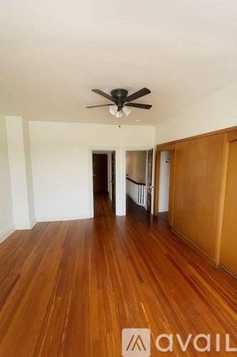 A room with wooden floors and a ceiling fan.