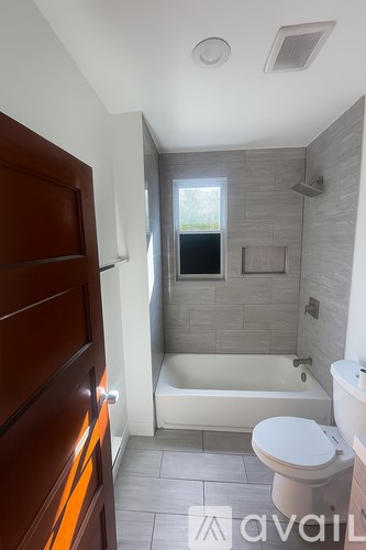 A bathroom with a toilet, a bathtub, and a shower.