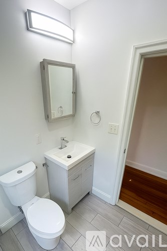 A white toilet and sink in a bathroom.