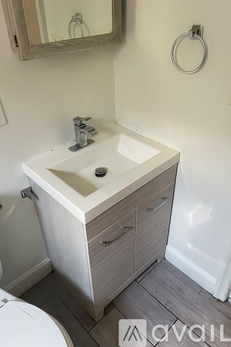 A white sink with a silver faucet and a mirror above it.