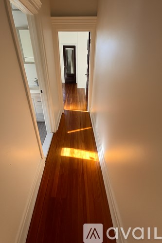 A hallway with wooden floors and a light on the floor.