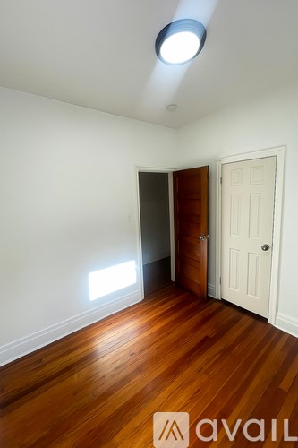 A room with wooden floors and a white door.