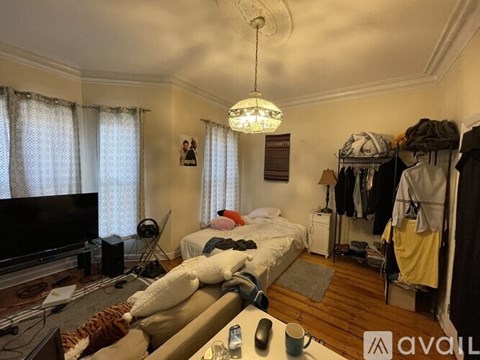 A living room with a couch, television, and a bed.