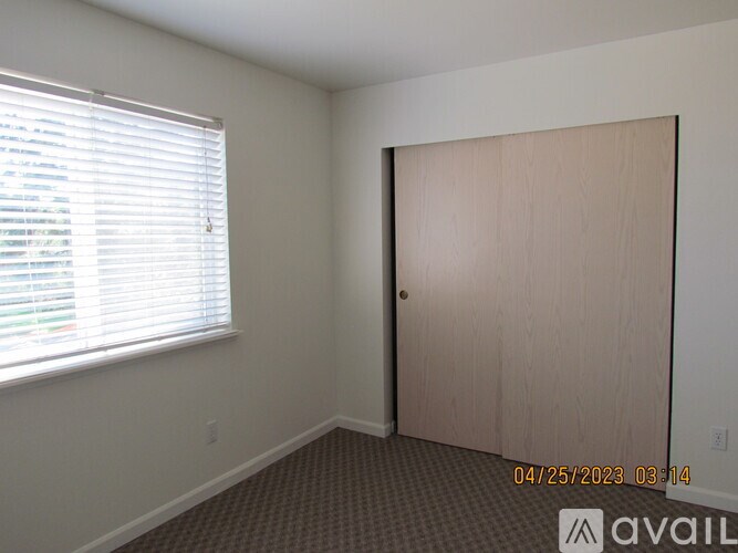 A room with a door, window, and carpeted floor.
