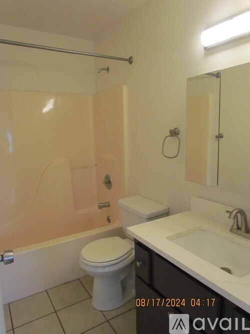 A bathroom with a toilet, sink, and shower.