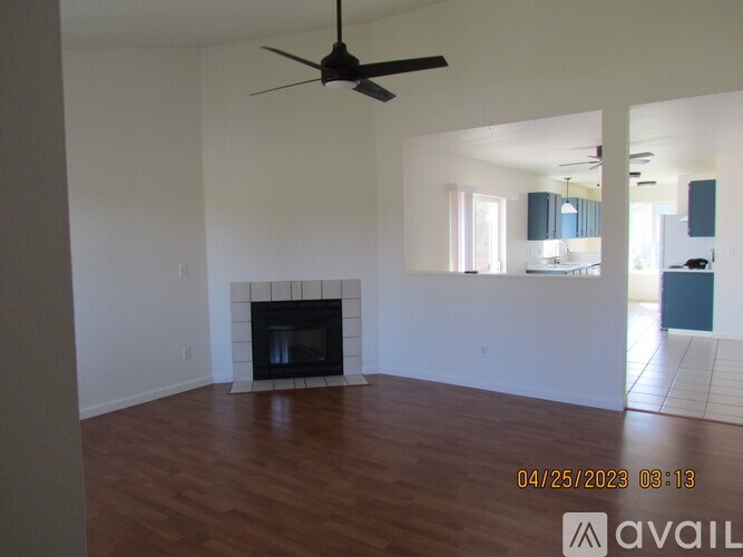 A room with a fireplace and a ceiling fan.