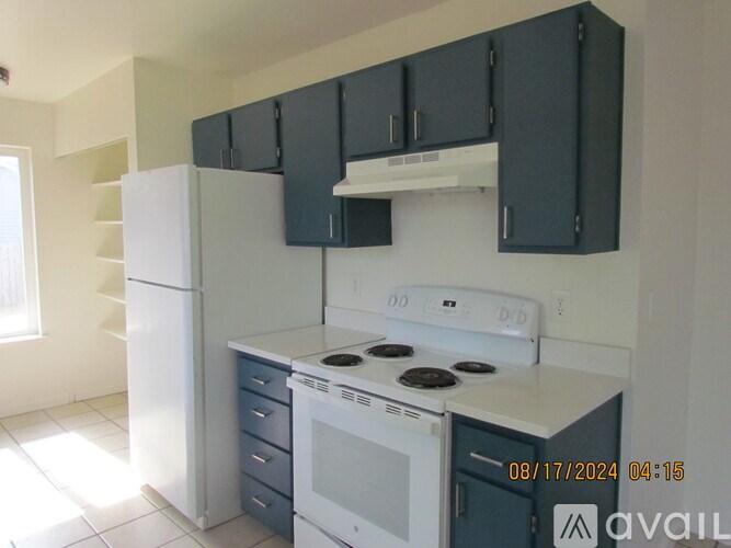 A kitchen with white appliances and black cabinets.