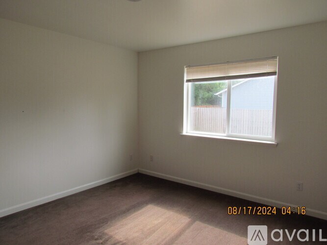 A room with a window and a wooden floor.