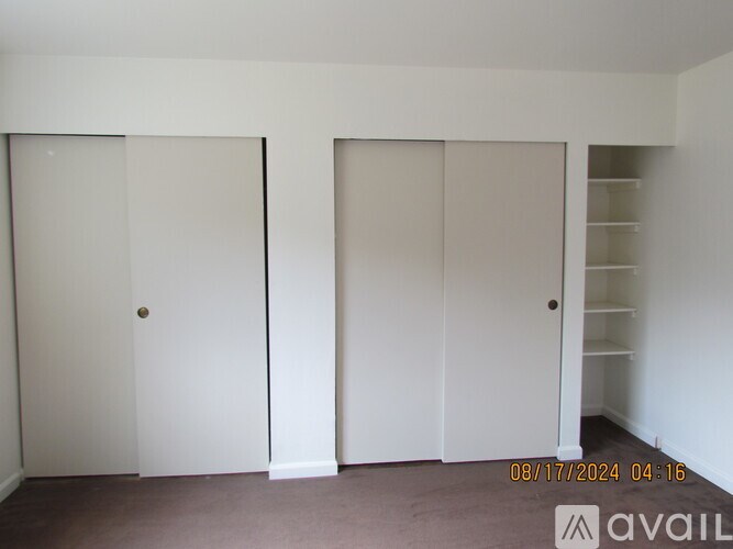 Two white closet doors in a room.