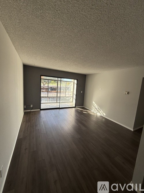 A room with a sliding glass door leading to a balcony.