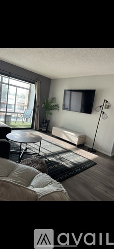A living room with a flat screen TV mounted on the wall.