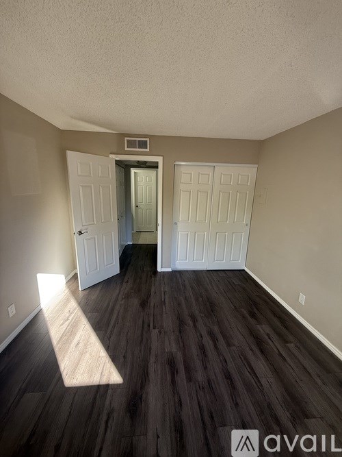 A room with wooden floors and two white doors.
