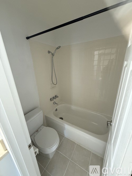 A white toilet is next to a bathtub in a bathroom.