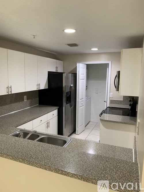 A kitchen with black and white cabinets and a granite countertop.