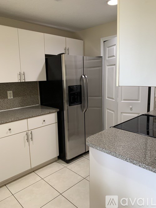 A kitchen with a black fridge and stainless steel appliances.