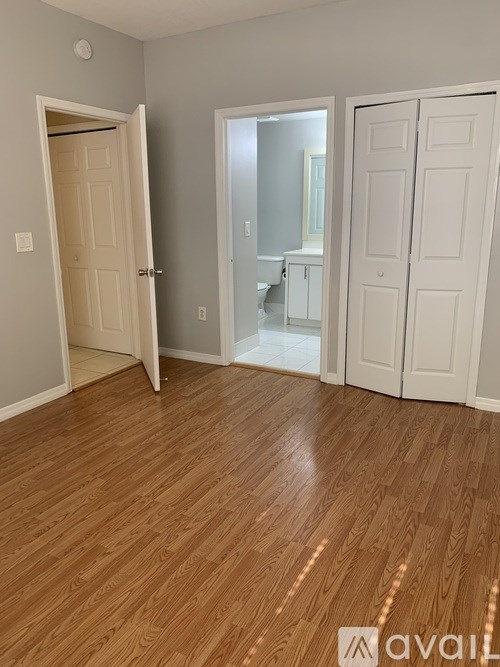A room with wooden flooring and two white doors.