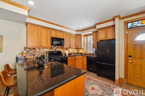A kitchen with wooden cabinets and a black countertop.