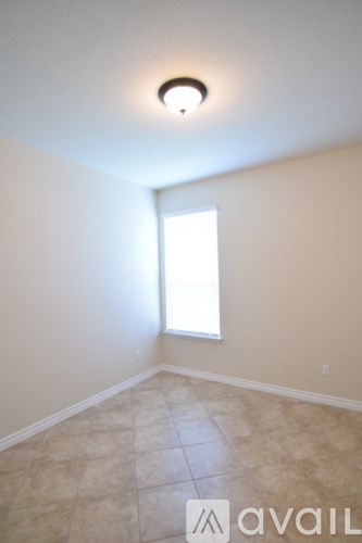 A room with a window and tiled floor.