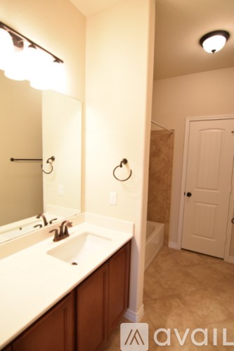 A bathroom with a sink, mirror, and towel rack.
