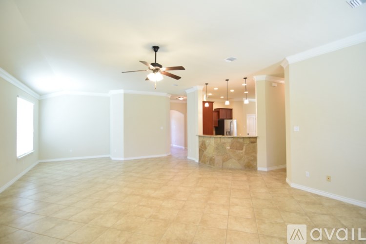 A spacious room with a fan and tiled flooring.