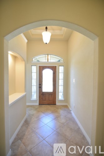 A hallway with a light on and a door at the end.