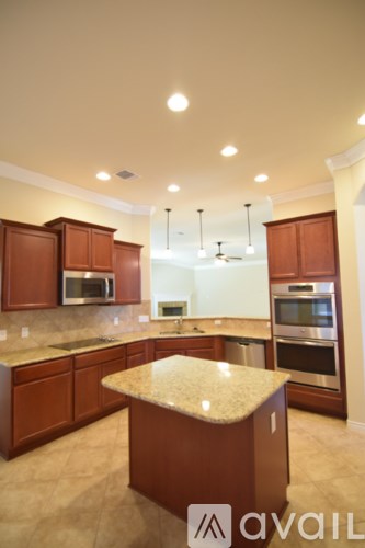 A kitchen with brown cabinets and a granite countertop.