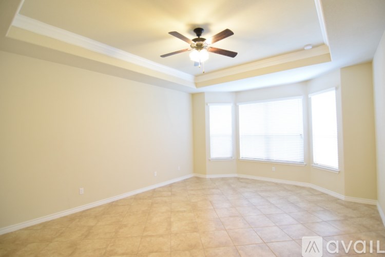 A room with a ceiling fan and tiled floor.