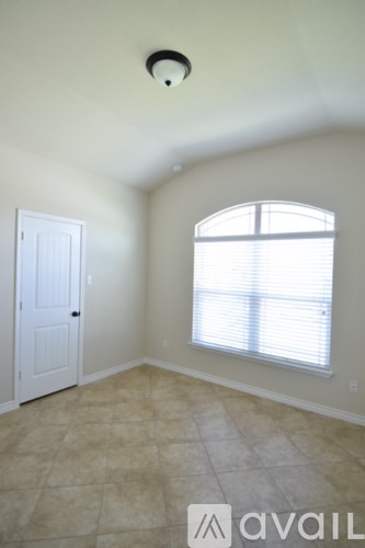 A room with a door and a window with blinds.